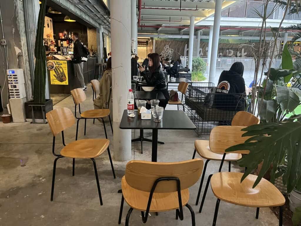 Dab haus outside seating area, man, woman, tables, chairs, concrete floor, courtyard, Daytime