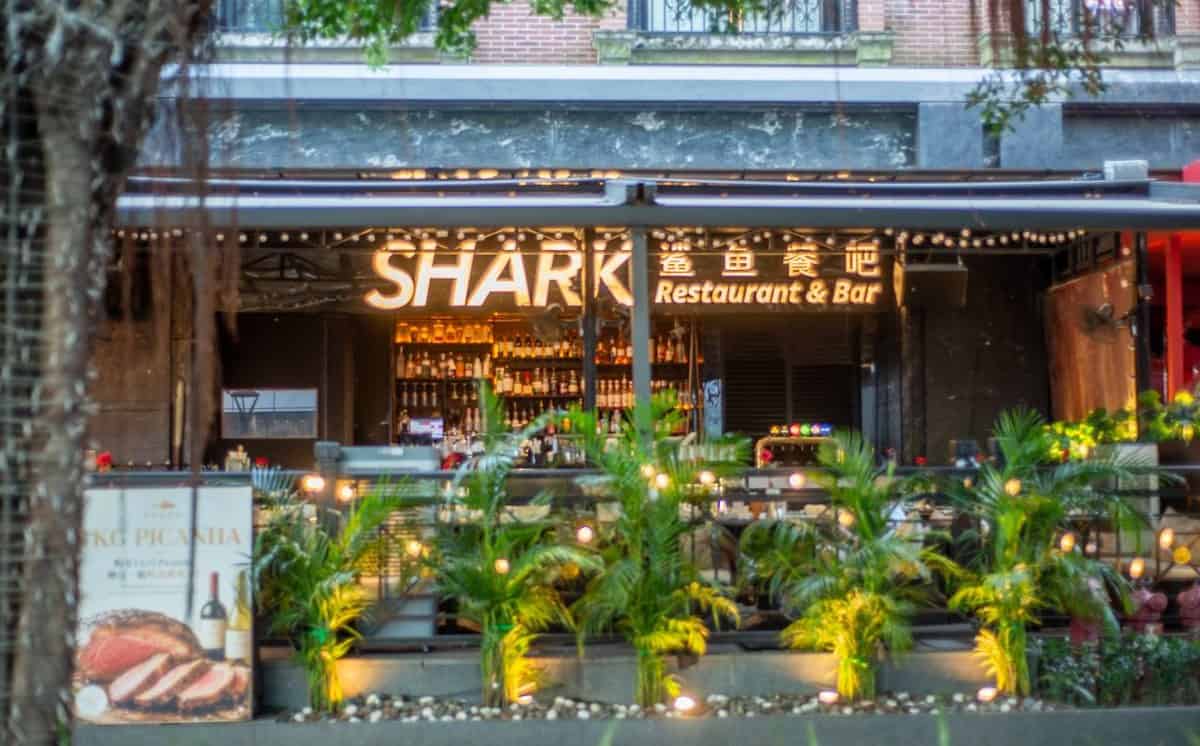 Coco Park SHARK exterior at dusk with string lights, plants and steak and wine sign — thirstyguide.com