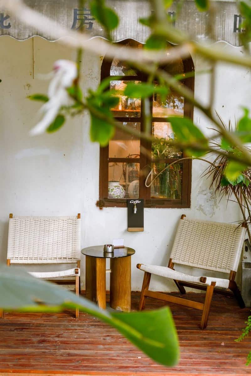 Two woven chairs and a table on the outdoor deck at Moon Ke Coffee (Moon可咖啡), Shenzhen — thirstyguide.com