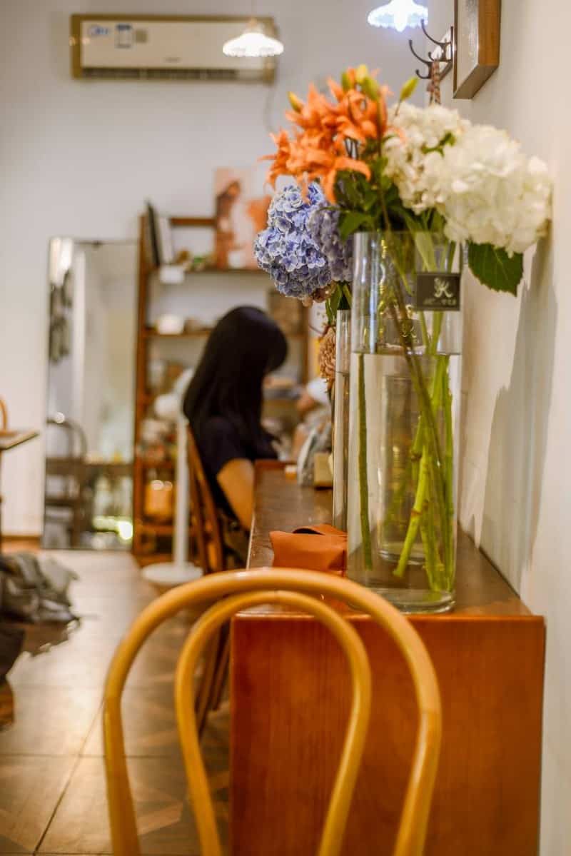 A vase of flowers on a counter at Moon Ke Coffee (Moon可咖啡), a coffee shop in Shenzhen, China — thirstyguide.com